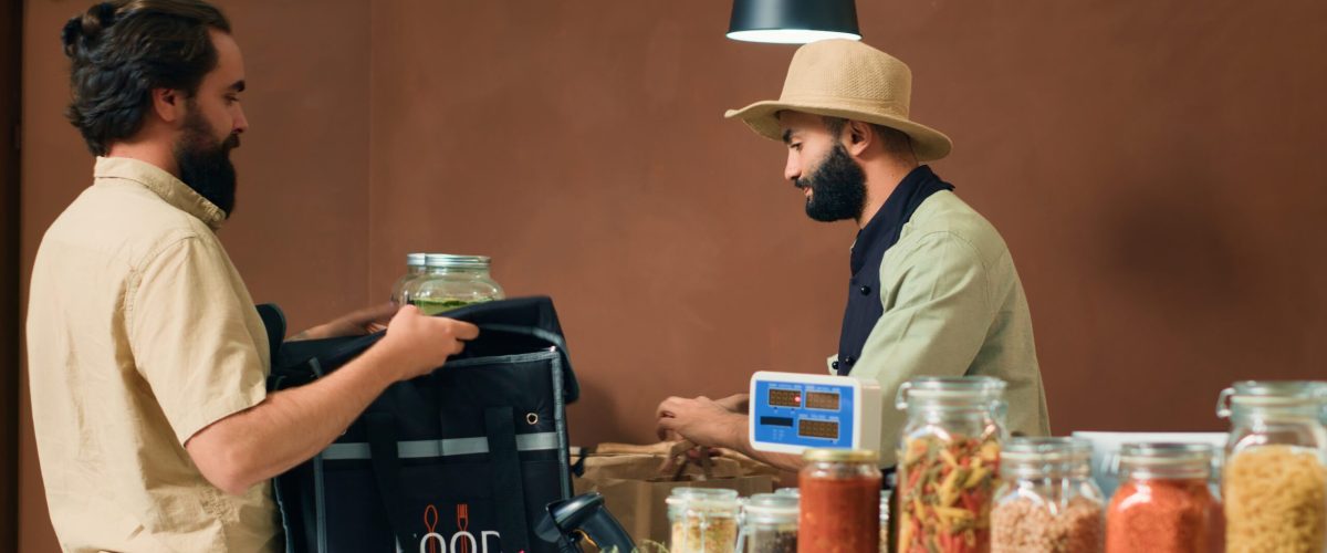 Deliveryman taking food supplies order with backpack to deliver organic freshly harvested produce to local clients. Employees preparing fruits and vegetables, sustainable lifestyle. Tripod shot.