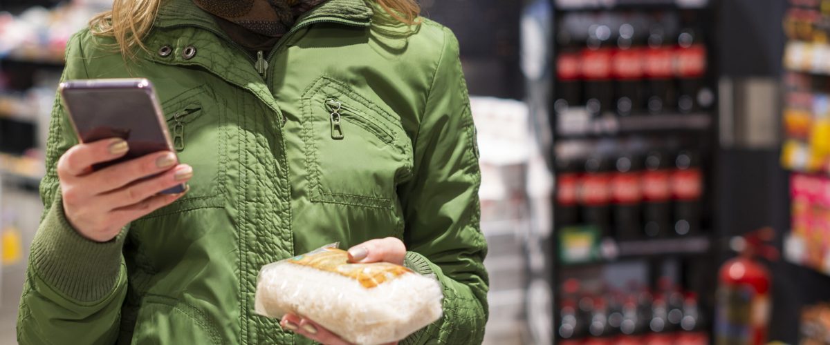 woman-with-protective-mask-using-her-mobile-phone-shop
